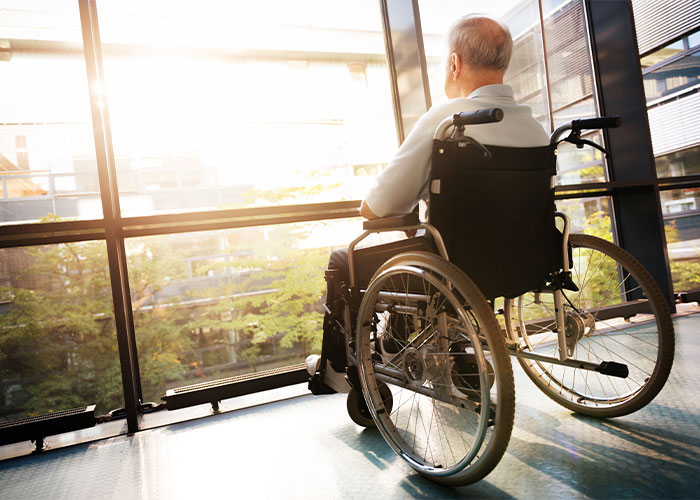 Image of a man in a wheelchair looking out of a window